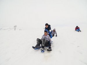 Çocukların karlı tepelerde kızak keyfi