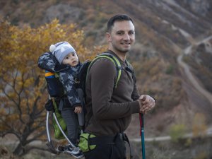 Sırtında 1 yaşındaki oğluyla vadilerde doğa yürüyüşüne çıkıyor